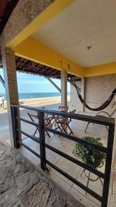 雷东达Chalés Canto do Mar的阳台配有桌子,享有海滩美景