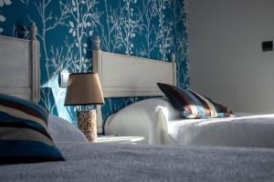 AbionzoCasa Rural Costalisa的一间卧室配有蓝色和白色壁纸的床