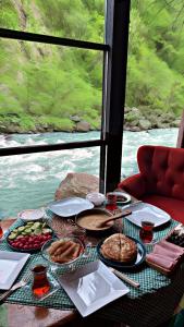 贾马里海姆森AYDER BUNGALOW - river view , Royal Bungalow Resorts的一张带食物的桌子,享有河景