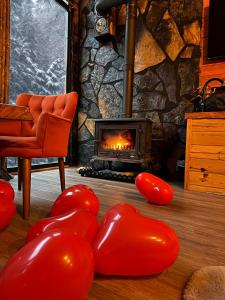 贾马里海姆森AYDER BUNGALOW - river view , Royal Bungalow Resorts的客厅设有壁炉和红色气球