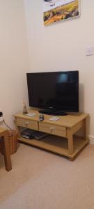 BuckinghamshireAylesbury Lovely Double and Single Bedroom with Guest only Bathroom的木桌旁的平面电视