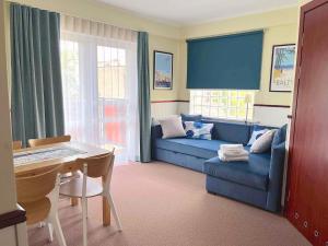 查普伊Villa Baltic Chałupy Apartament 4的客厅配有蓝色的沙发和桌子