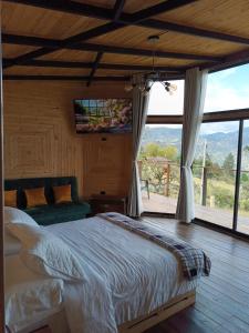 MachetáGlamping Caelum. Refugio al aire libre, en Macheta Cundinamarca的一间卧室设有一张床和一个大窗户