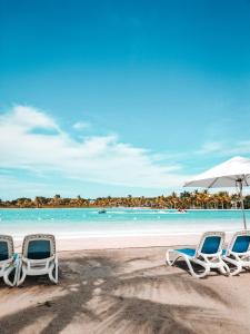普拉亚布兰卡ABBY TOURISM的海滩上的三把躺椅和一把遮阳伞