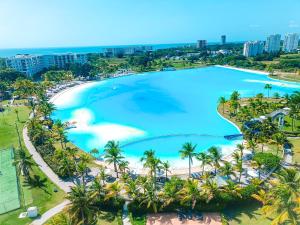 普拉亚布兰卡ABBY TOURISM的享有棕榈树大型游泳池和海滩的空中景致