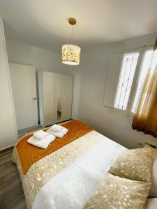 马德里Madrid Centro的一间卧室配有两张床和吊灯。