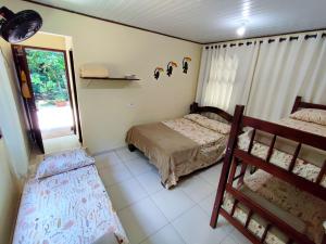 伊利亚贝拉Chalé da cachoeira - Ilhabela的一间卧室设有两张床和窗户。