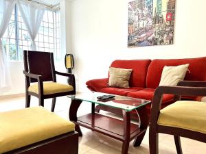 巴耶杜帕尔Apartamento Cerca Al centro的客厅配有红色的沙发和两把椅子