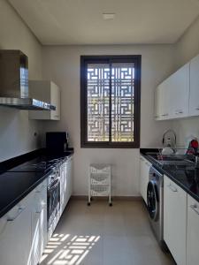 塞拉Appartement a la marina de salé的厨房配有洗衣机和烘干机以及窗户。