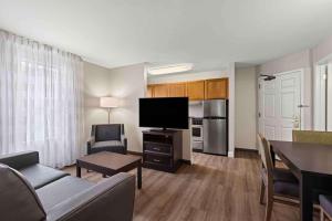 芬顿Extended Stay America Suites - St Louis - Fenton的带沙发、电视和桌子的客厅