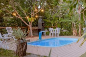 普拉亚多Aruana Suites Tranquilidade e Sossego no meio da Natureza a 5km da Vila de Praia do forte的木制甲板上的带喷泉的游泳池