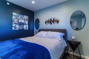 埃尔帕索Discover the Ultimate Trending Hot Tub Retreat的一间蓝色卧室,配有一张床和两面镜子