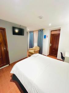伊瓦拉Quinta San Carlos Hostel的酒店客房,配有白色的床和椅子