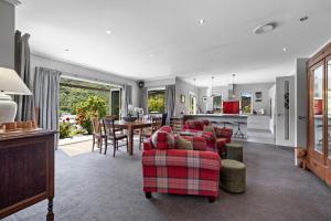 箭镇Elite Holiday Homes Queenstown - Arrowbrae的一间带红色沙发的客厅和一间厨房
