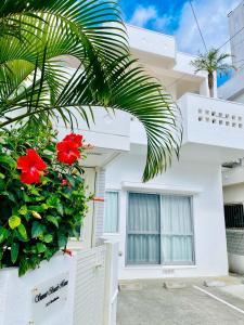 北谷町Sunset Beach House的前面有红花的白色房子