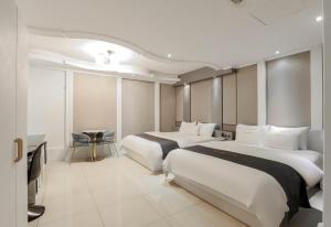 浦项Renaissance Hotel Pohang的酒店客房设有两张床和一张桌子。