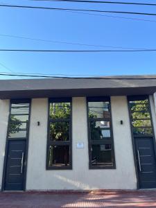 拉里奥哈Solares, Departamento zona centro的一座建筑,设有四扇窗户和蓝色门