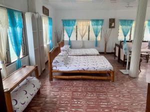 利安Tamari's Rest House的配有蓝色窗帘的客房内的两张床
