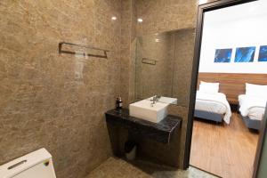 Trảng BàngGems Hotel - Khách sạn Trảng Bàng的一间带水槽、床和镜子的浴室
