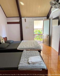 隆海Mai Anh Homestay Long Hải的小房间设有两张床和窗户