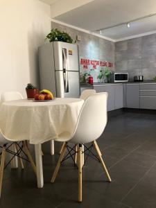门多萨CASA GRANDE的厨房配有白色的桌子和冰箱。