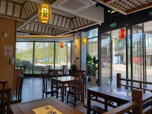 苏州苏州新区科技城壹棠服务公寓的餐厅设有木桌、椅子和窗户。