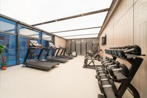 苏州苏州新区科技城壹棠服务公寓的健身房,配有一排跑步机和机器