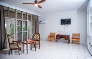 太平洋港Yatu Lau Lagoon Resort Fiji的客厅配有椅子、桌子和吊扇