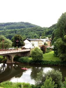 沃伦道夫庞特Logis Hotel-Restaurant Dimmer的一座河上的桥梁,有一座城镇的背景