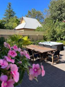 奥尔伯里Porters Cottage Oasis的后院的一张野餐桌,里面种着粉红色的花