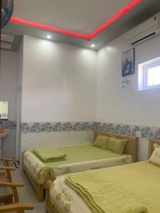 广义Nhà nghỉ Bá Thành - Lý Sơn的客房设有两张床和红色天花板。