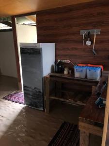 PareaFARE Tatahi的厨房配有冰箱和带水桶的柜台