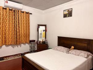 TudugalaCozy village house的一间卧室配有一张床、梳妆台和镜子
