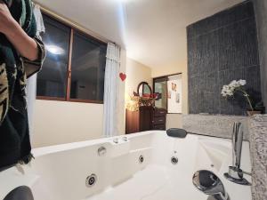 巴尼奥斯TURI Suite con Jacuzzi, centro de la ciudad的白色浴缸、水槽和窗户