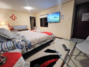 巴尼奥斯TURI Suite con Jacuzzi, centro de la ciudad的一间卧室配有一张床和一张玻璃桌
