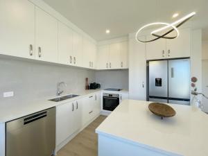 奥克兰Your Modern Home in Sandringham, Close to City, Heat Pumps, Netflix, Parking的厨房配有白色橱柜和白色台面