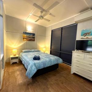 Wagait BeachUnit 3 Golden Sands Retreat的一间卧室配有一张床、梳妆台和电视。
