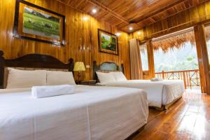 宁平Hang Lan Bungalow的配有木墙和木地板的客房中的两张床