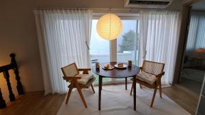 釜山Soban Stay的一间带桌椅和台灯的用餐室