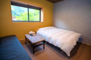 立山町LOCOMOTION COFFEE AND BED的一间卧室配有一张床和一张桌子及窗户