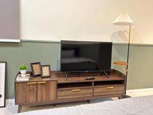 新山Paradigm Residence Studio 4pax 2King bed Netflix WiFi的木质娱乐中心顶部的平面电视