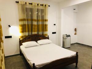 阿杭格默Villa Bilimbi的一间卧室配有一张带白色床单的床和一扇窗户。