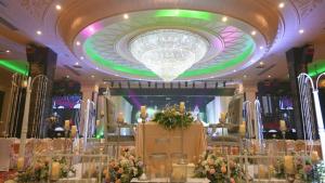 哥打巴鲁Renai Hotel Kota Bharu的一间设有大吊灯和鲜花的房间
