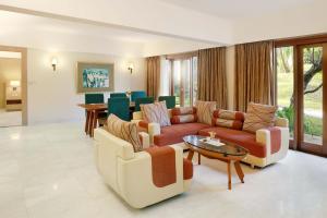 泗水Grand Tropic Suites Hotel Surabaya的带沙发和桌子的客厅