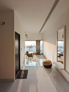 曼德姆Aqua Beach Resort Ashwem的客厅设有白色的墙壁和大窗户