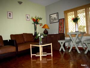 科代卡纳尔LEELA's COUNTRY HOUSE的客厅配有沙发和鲜花桌