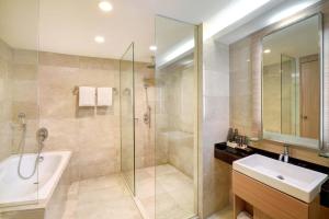 泗水Grand Tropic Suites Hotel Surabaya的带淋浴、浴缸和盥洗盆的浴室