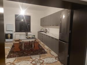 Türkistanmunazhat的厨房配有桌子,墙上配有电视。