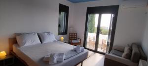 KamáriaLIOFYTO - Stylish villa with views to Foinikounda bay的一间带大床的卧室和一个阳台
