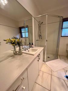 奥尔伯里Grand retreat in town的浴室配有水槽和鲜花淋浴
